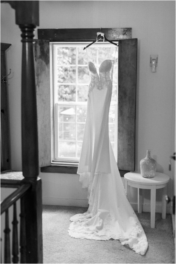 Allure bridal gown from Trudy's Brides hanging in the window of a hallway at a Twenty Mile House wedding